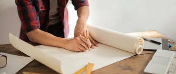 Hombre dibujando en un plano para explicar la fabricación de concreto